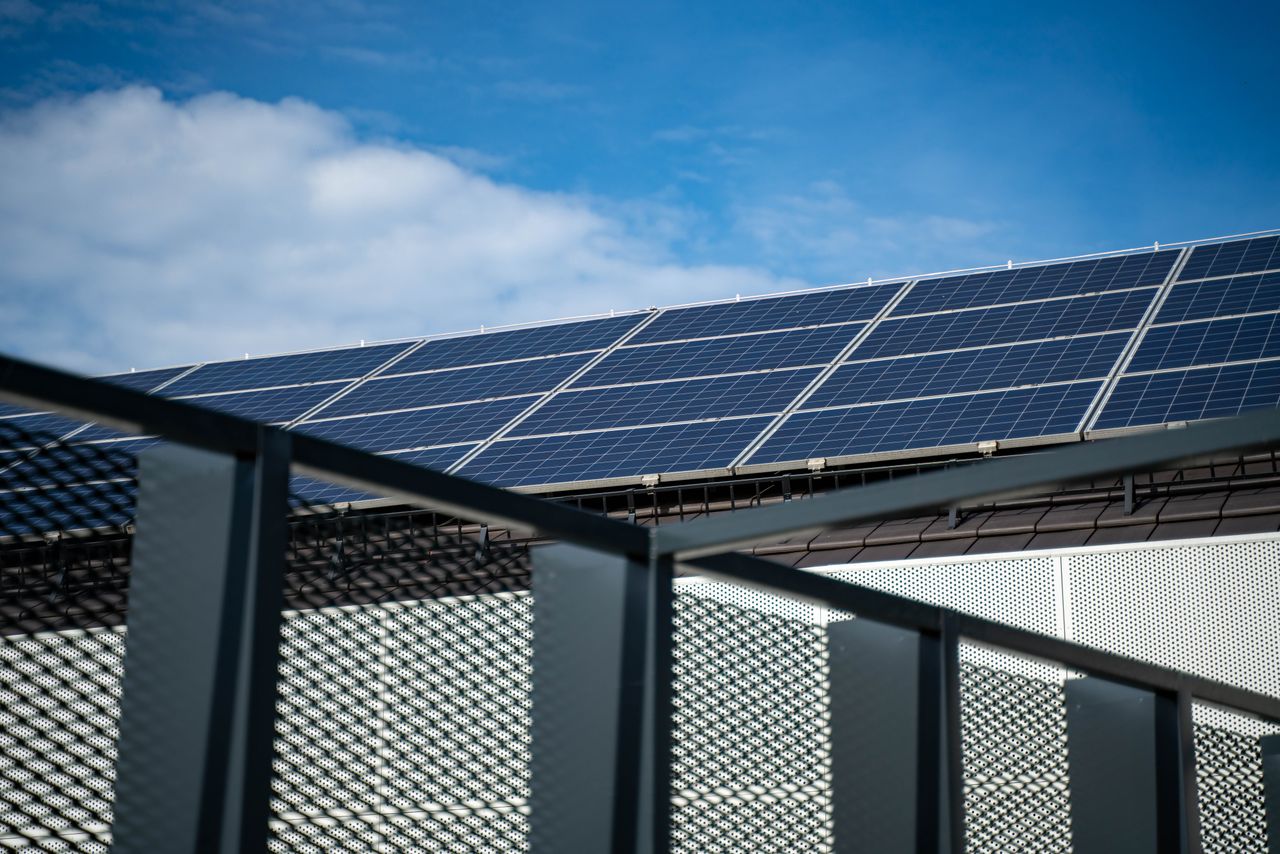 services-02 Close-up view of modern solar panels on a rooftop against a clear blue sky, representing clean energy.